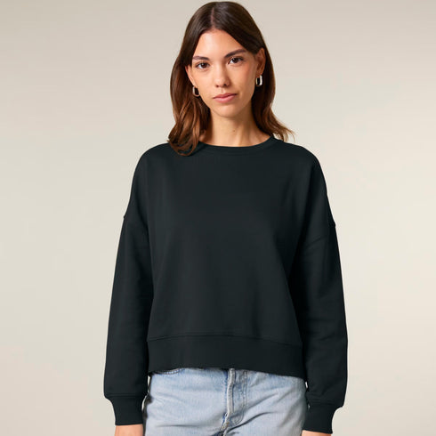 A woman wearing a black organic cotton crew neck sweatshirt.
