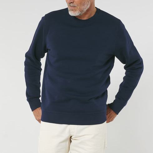 Man wearing a navy blue organic crewneck sweater