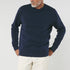 Man wearing a navy blue organic crewneck sweater
