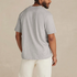 Man wearing a light gray heather organic cotton crewneck t-shirt from a rear three-quarter angle.